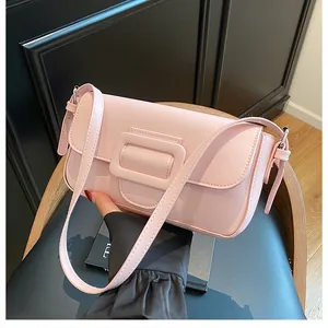 Detail of light pink shoulder bag featuring a square buckle and smooth leather texture
