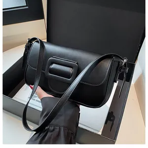 Detail of a black matte baguette shoulder bag with a large decorative square buckle