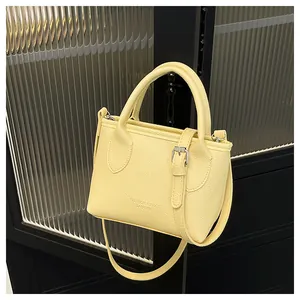 Close-up of light yellow bucket bag with lychee grain texture and metal buckle detail