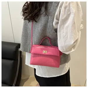 Detail view of pink Kelly bag featuring houndstooth texture and metal turn-lock closure
