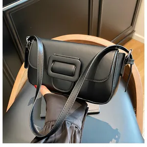 Close-up of black matte leather shoulder bag with a signature oversized buckle detail