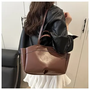 Detail of dark brown leather tote bag with white contrast stitching and large capacity