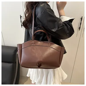Detail shot of vintage brown tote bag featuring contrast stitching and leather texture