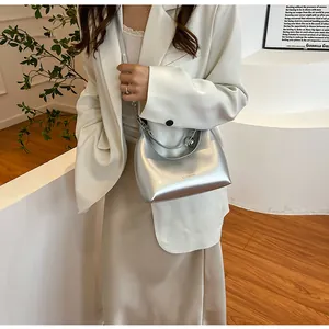 Gros plan du sac demi-lune argenté brillant avec le logo CLEARDK gravé sur le devant
