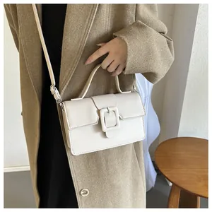 Niche cream rectangle flap handbag with square buckle shown on camel wool coat