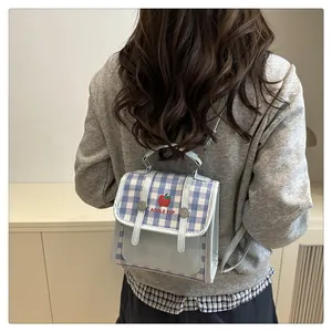 Detailed view of mini checkered backpack with apple embroidery and blue leather trim