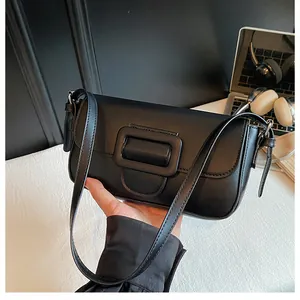 Detailed view of black leather shoulder bag with square buckle flap and slim strap
