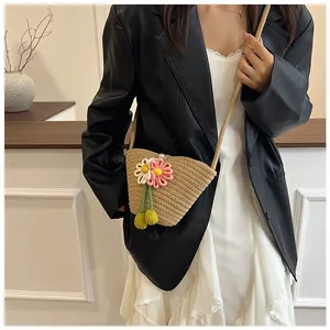 Detail of hand-woven beige cotton rope beach bag with 3D floral accents and strap