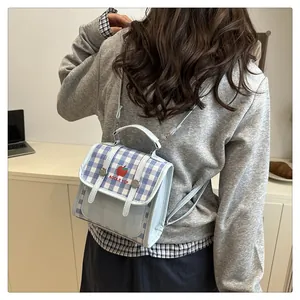 Detail of light blue checkered mini backpack with apple logo and adjustable straps