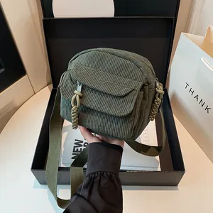 Minimalist dark green corduroy square shoulder bag with woven strap and front pocket