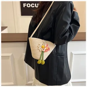 Detail of woven beach bag with floral decorations and pearl clasp on a black blazer
