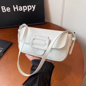 Minimalist white baguette bag with square buckle on a wooden table, retro shoulder style