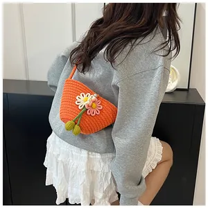 Detailed view of woven orange flower bag with daisy accents and pearl buckle detail