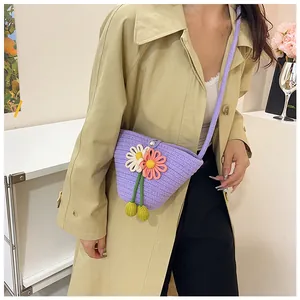 Close-up of a purple woven crossbody bag with white daisy crochet floral details