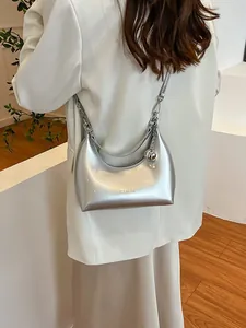 Sac hobo argenté brillant en forme de croissant avec pendentif boule métallique chic