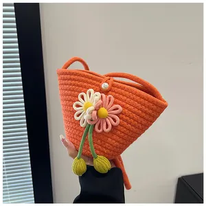 Detail of hand-woven orange cotton rope bag with crochet flowers and pearl button