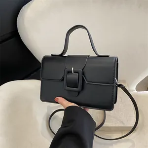 Classic black leather handbag with square buckle featuring a top handle and shoulder strap