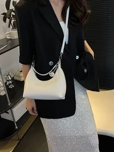 Sac sous le bras blanc verni en demi-lune avec fine bandoulière et pendentif boule
