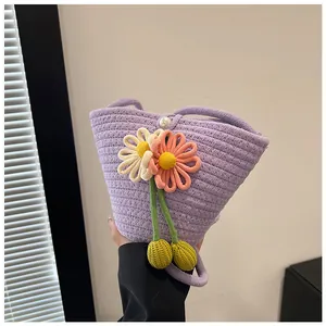 Detailed close-up of woven lavender bag with decorative floral motifs and pearl clasp