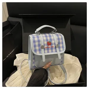 Detail of blue plaid mini backpack with apple print inside a premium gift box