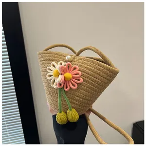 Detail of woven beach bag showing delicate floral embroidery and decorative pearl closure
