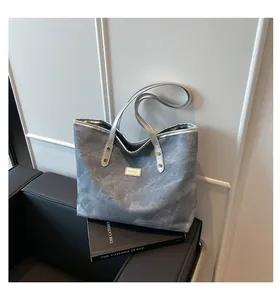 Close-up of retro large capacity denim tote bag with silver leather trim and fashion label