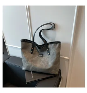 Detailed macro view of gray marble pattern tote bag with golden metal rivets and fashion label