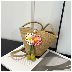 Detail of woven straw bucket bag with floral crochet accents and pearl closure