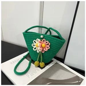 Close-up of green woven bucket bag with 3D floral accents and elegant pearl clasp
