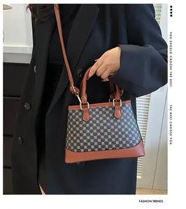 Model wearing a retro printed crossbody bag with contrast stitching in an indoor setting
