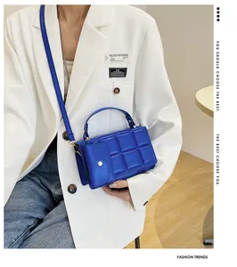 Detail of royal blue quilted handbag with matching small pouch and golden hardware
