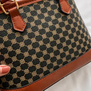 Close-up of vintage monogram pattern with brown leather trim and gold metal hardware