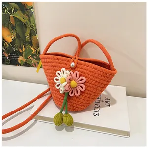 Detailed weave of orange rope bag featuring knit flowers and a large pearl clasp detail