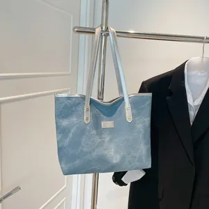 Retro blue denim tote bag with silver handles and a metallic Fashion label design