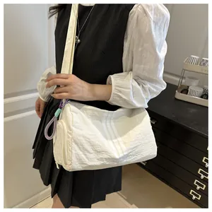 Detail of white nylon sports bag with triple vertical stripes and adjustable strap