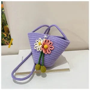 Close-up of handmade purple woven bucket bag with 3D floral accents and pearl closure