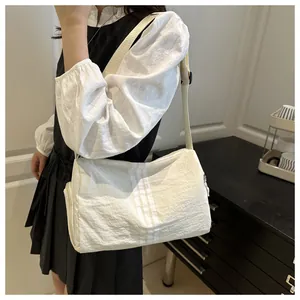 Detail of a lightweight cream nylon travel bag featuring vertical stripes and wide strap