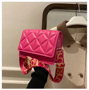 Detail of hot pink quilted crossbody bag featuring a stylish wide patterned fabric strap