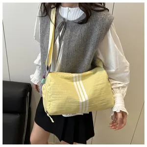 Close-up of lightweight pale yellow yoga travel bag with three vertical white stripes