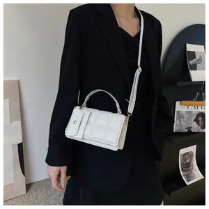 White quilted faux leather crossbody bag styled on a model wearing a black blazer