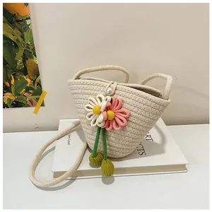 Detail of woven cotton rope beach bag with crochet daisies and a pearl closure buckle