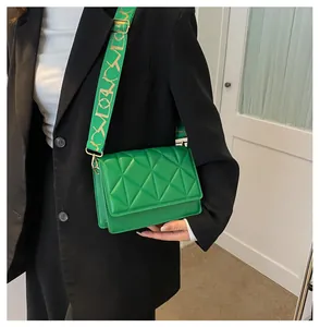 Detail of the geometric quilted green crossbody bag with wide jacquard shoulder strap