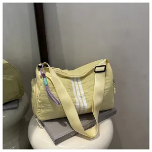 Detail of light yellow fitness duffel with white stripes and woven colorful lanyard