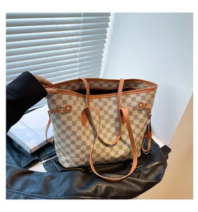 Dettaglio borsa tote a scacchi con manici in pelle marrone e fibbie in metallo dorato