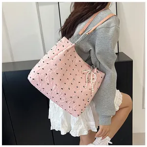 Detail of pink tote bag with black butterfly prints and elegant pearl bow charm