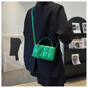 Detail of bright green quilted handbag styled with a black blazer for chic outfit contrast