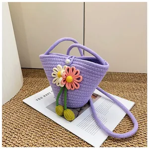 Detail of purple woven bucket bag with 3D crochet flowers and pearl button closure