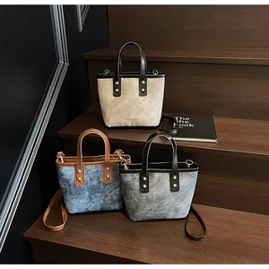 Close-up of three mini bucket bags with distressed leather texture and gold metal rivets