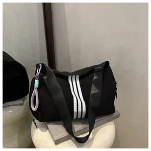 Close-up of black gym bag featuring three white stripes and a colorful zipper pull detail