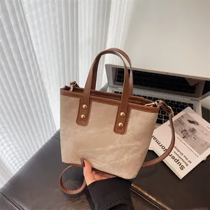 Fashionable beige canvas bucket bag with brown leather trim for commuting style